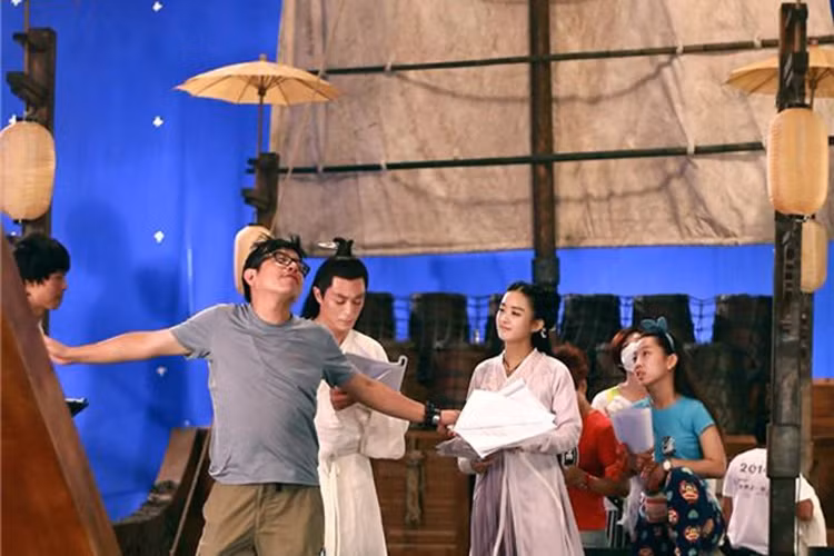 Tuy nhiên, ngoài hai diễn viên chính, trên thuyền còn có hơn chục người ở đoàn phim. Đạo diễn đang thị phạm một cảnh quay cho tiểu hoa đán họ Triệu.