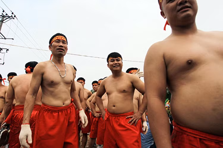 “Thời đó, người dân vẫn gánh nước bằng quang làm từ dây song, khi hai bên giằng co sợ đổ nước nên phải ngồi xuống đất để ôm lấy cả thùng nước mà kéo. Về sau khi hạn hán qua đi để tưởng nhớ tích xưa các cụ nghĩ ra trò kéo co ngồi để trình diễn trong hội làng với mong muốn cầu cho mưa thuận, gió hòa. Đây cũng là nét độc đáo của lễ hội làng Ngọc Trì mà không ở đâu có” ông Phụ chia sẻ.