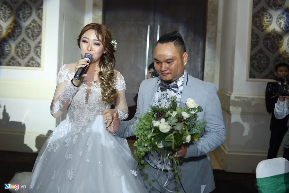 Vinh Râu dắt tay vợ lên sân khấu. Hôn lễ của cặp 23 tuổi diễn ra với sự chứng kiến của gia đình và nhiều bạn bè thân thiết trong giới giải trí.