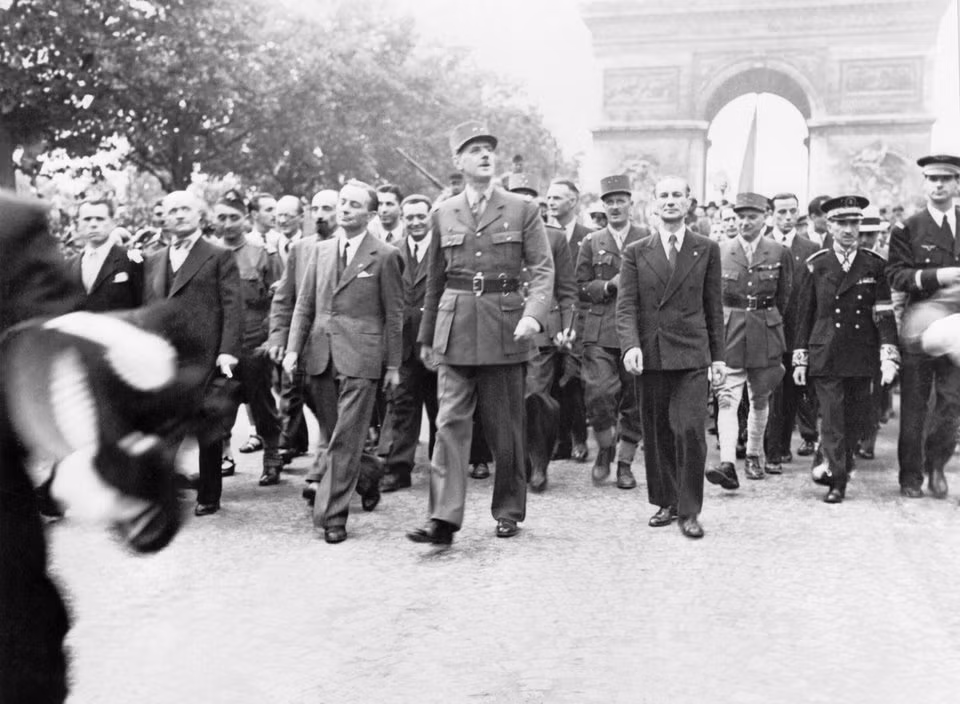 Tướng Charles de Gaulle cùng đoàn tuỳ tùng của mình dạo bước qua Khải Hoàn Môn - một điều mà trước đó chỉ một năm không một ai trong số những nhân vật này dám nghĩ tới. Nguồn ảnh: BI.
