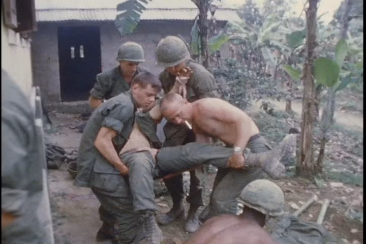 Lính Mỹ sơ tán đồng đội bị thương ra khỏi một khu vực có vẻ như là một ngôi nhà của người dân địa phương, nhiều khả năng đây là hình ảnh được ghi lại trong một trận càn của binh lính Mỹ. Nguồn ảnh: Thearchive.
