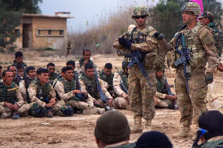 Binh sĩ lục quân Iraq theo dõi các quân nhân Mỹ hướng dẫn về kỹ thuật di chuyển và chiến thuật cấp tiểu đội tại trại huấn luyện Taji ở Iraq vào ngày 24/3/2015.