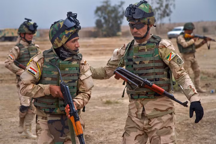 Hạ sĩ Iraq (phải) hướng dẫn lính của mình tư thế đúng. Sau khi IS trỗi dậy ở Iraq vào năm 2014, Mỹ đã tập trung huấn luyện quân đội bản địa để đối đầu với phiến quân Hồi giáo cực đoan.