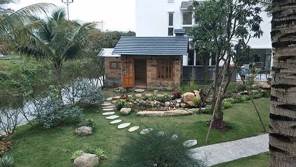 Bao quanh ngôi nhà là lớp đá lớn và phủ lên đó là cỏ xanh.