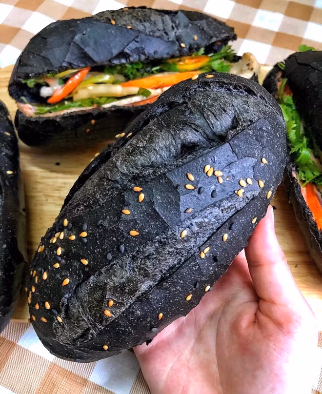 Bánh mì đen không bán rời mà được kẹp cùng 6 loại nhân như chả mực, cua bể, xíu mại tôm, gà nướng, bò nướng phô mai và heo quay với mức gia dao động khoảng 20.000-45.000 đồng. Ảnh: Zing.