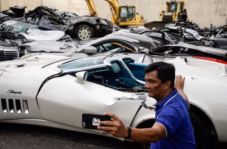 Người đàn ông chụp ảnh "tự sướng" cạnh đống xe sang vừa bị nghiền nát.
