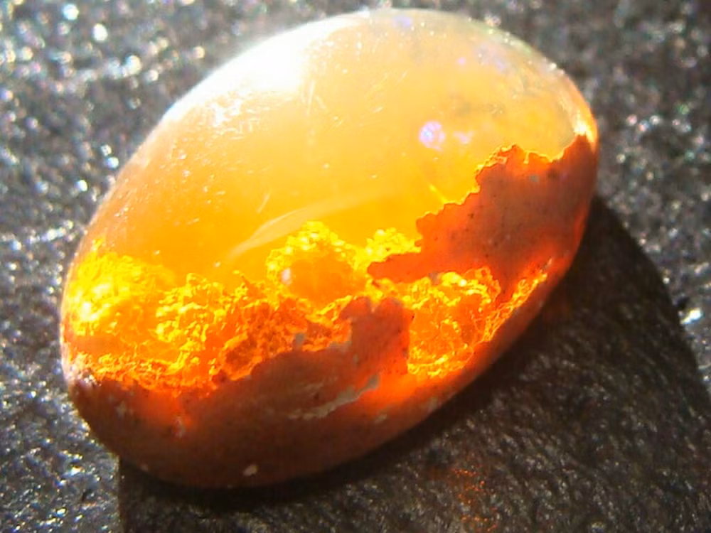 Viên đá lửa opal này giống hệt như viên đá thần kỳ chứa cả một bầu trời hoàng hôn vàng rực trong nó. (Nguồn Brightside)