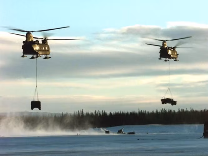 Hai chiếc trực thăng CH-47 Chinook chuẩn bị "thả" xe quân sự xuống nơi tập kết.