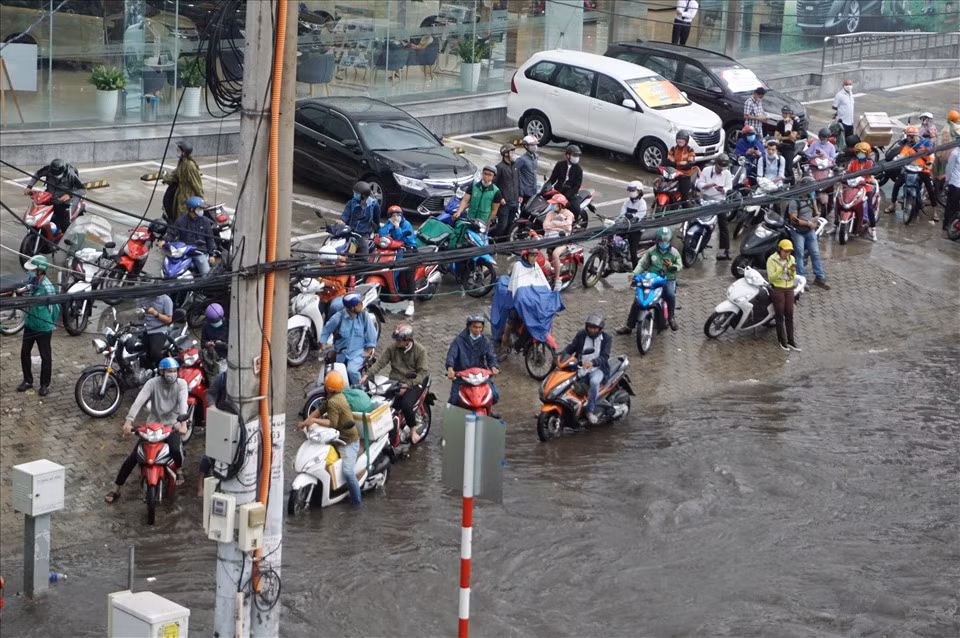 Đường ngập sâu, hàng loạt phương tiện phải dừng lại trên vỉa hè chờ nước rút mới có thể di chuyển tiếp.
