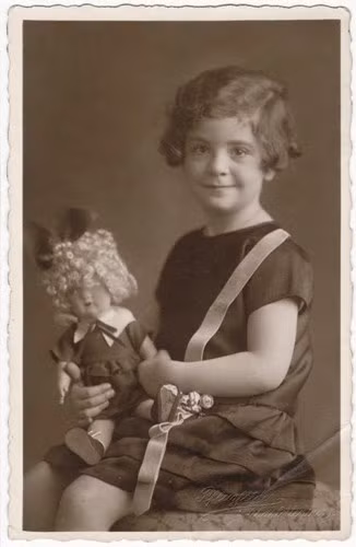 Marion Bassfrend chụp ảnh cùng búp bê ở Anh vào năm 1938. Bố mẹ của em đã bị Đức Quốc xã giết hại vào tháng 11/1941 tại Kaunas.