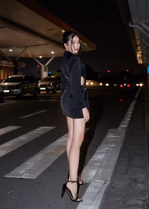 Nàng á hậu đeo túi xách, đi giày cao gót đen cùng tông màu trang phục tạo nên một phong cách cực kỳ sang chảnh, bí ẩn.