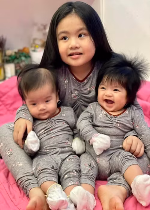 Bé Queenie rất yêu thương và thích chơi với hai em gái.