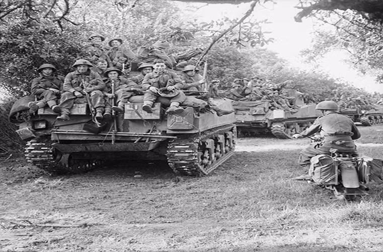 Xe tăng Sherman thuộc lữ đoàn thiết giáp 27 của Anh mang theo bộ binh của sư đoàn 3 di chuyển về điểm tập kết trước giờ Chiến dịch Goodwood bắt đầu. Bức ảnh này được chụp vào ngày 18/7/1944.