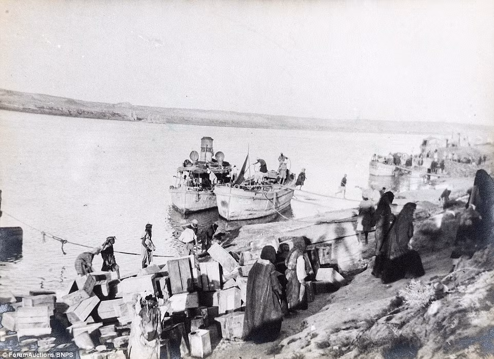 Những phụ nữ Iraq đang bỏ những thùng rỗng lên tàu bên bến sông Euphrates. Ảnh Daily Mail