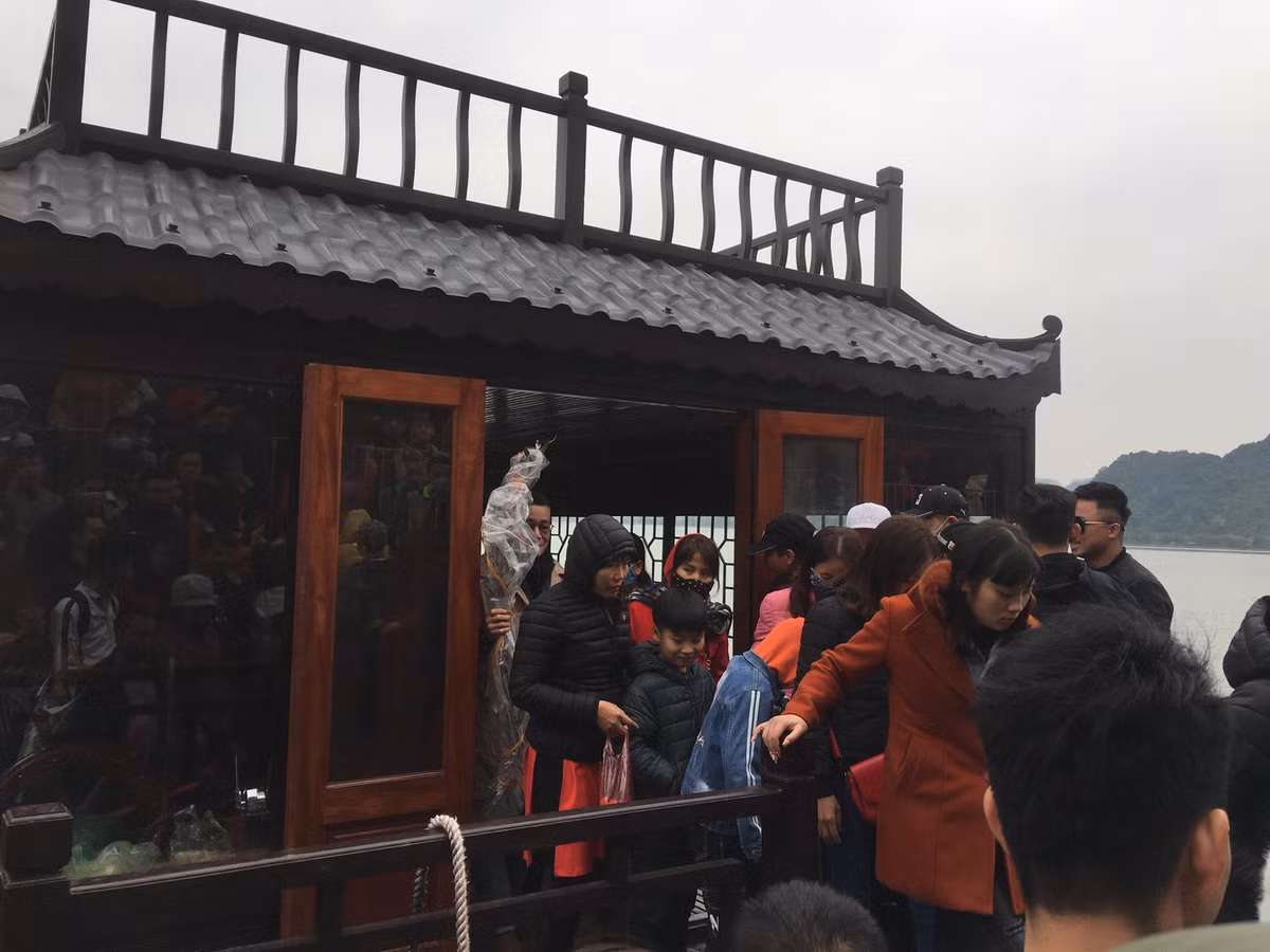 ...Du khách từ thuyền lên ngôi chùa giữa đảo.