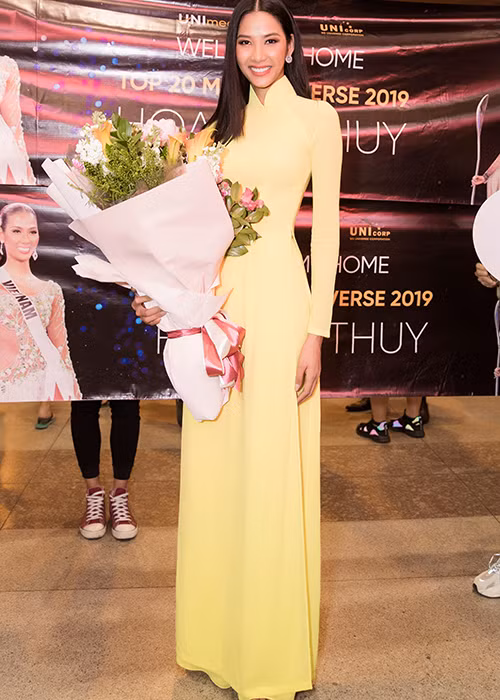 Á hậu Hoàng Thùy diện áo dài khi trở về nước.