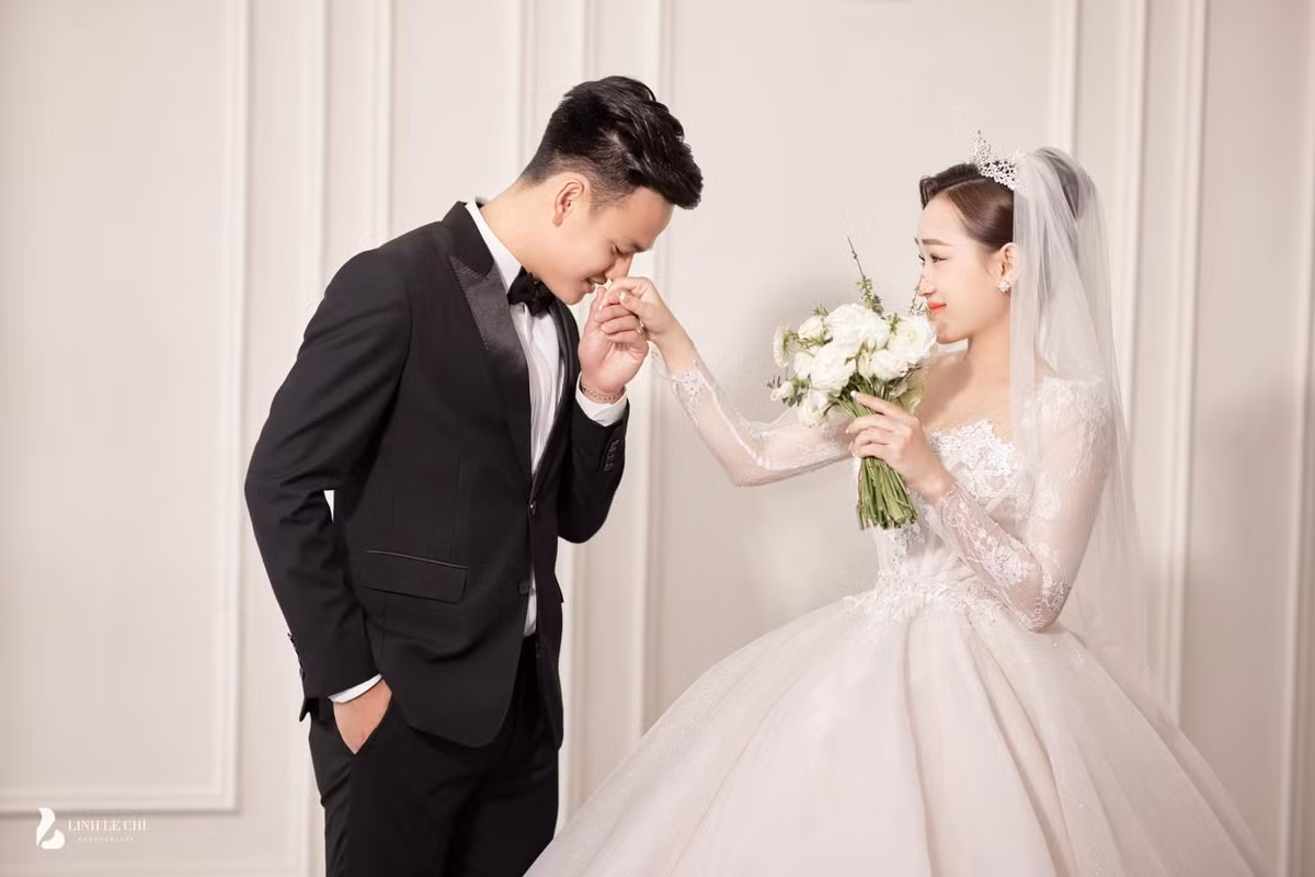 Trong loạt ảnh, Phạm Thị Hiếu chọn váy cưới trắng đơn giản nhưng không kém phần hiện đại, chú rể bảnh bao trong bộ vest.
