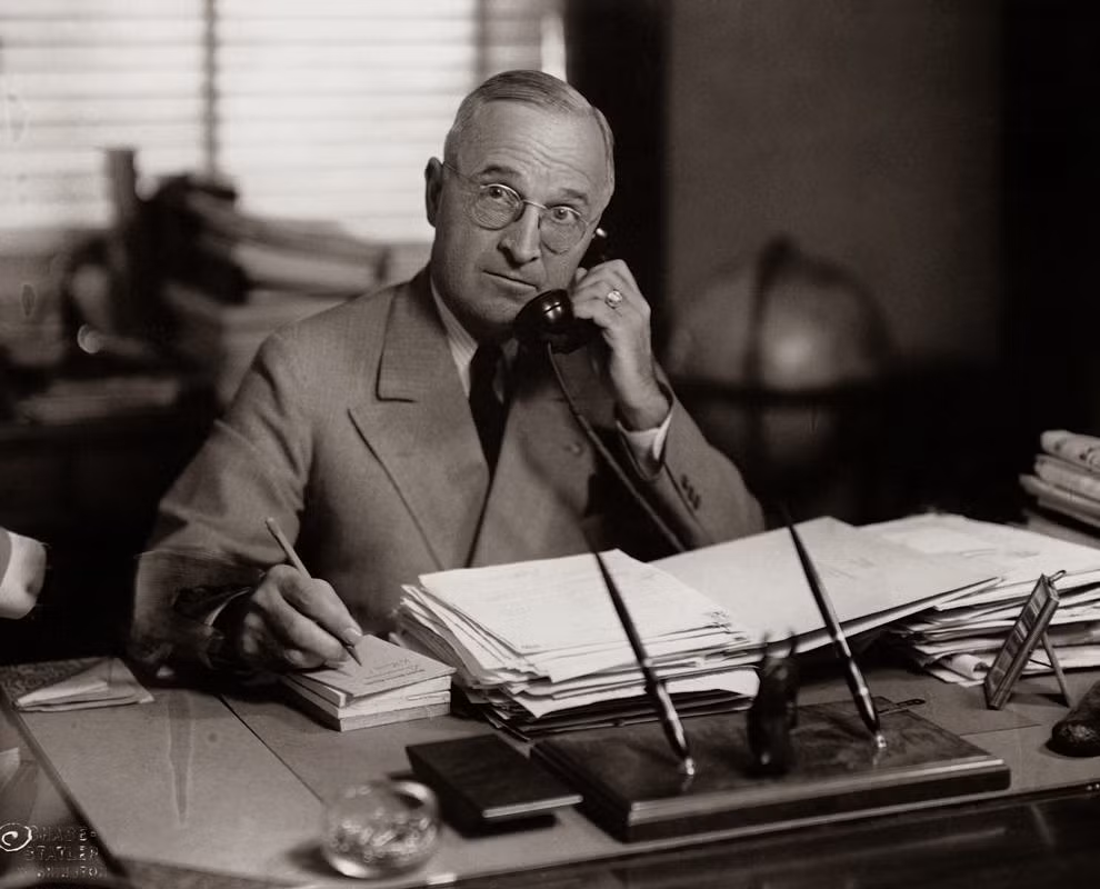 Tổng thống Harry Truman vừa gọi điện thoại vừa viết những điều quan trọng ra giấy. Ảnh chụp tại văn phòng ở Nhà Trắng năm 1945.