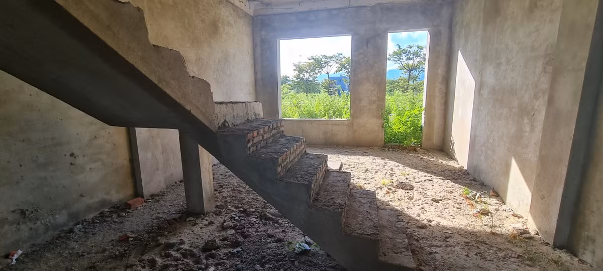 Cầu thang được đặt ở cuối căn nhà, bên ngoài là cỏ dại ngập lối, thò vào tận cửa sau.