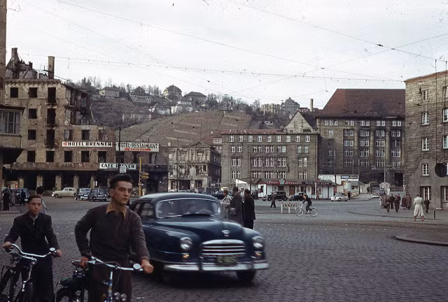 Hai thanh niên dắt xe đạp trên đường phố ở Arnulf Klett Platz, Stuttgart, năm 1951.