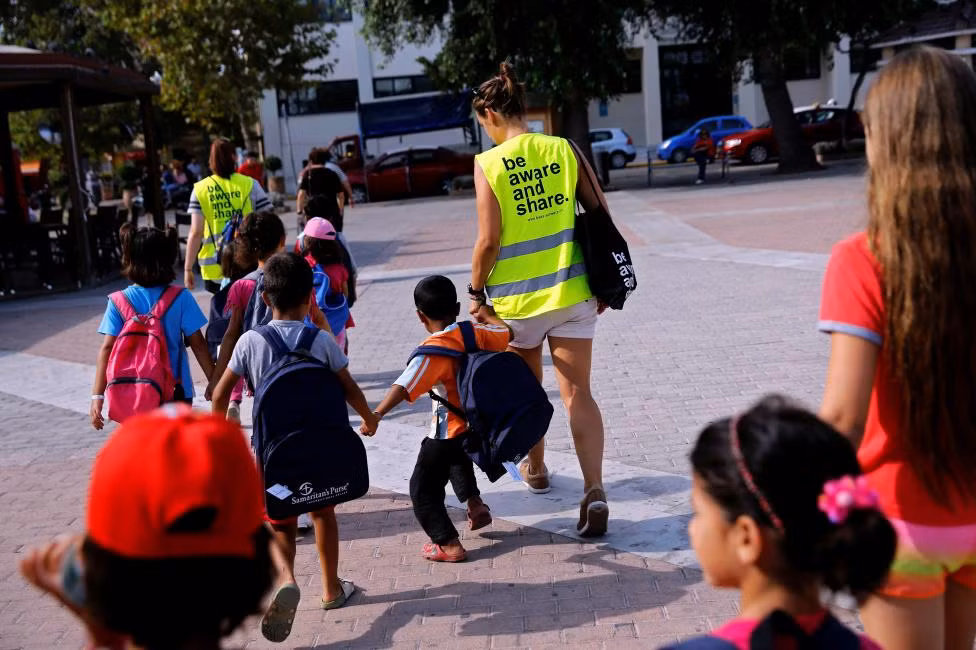 Các tình nguyện viên đưa một số em nhỏ tới trường học “Refugee Education Chios” dành cho người tị nạn trên đảo Chios hôm 14/9.