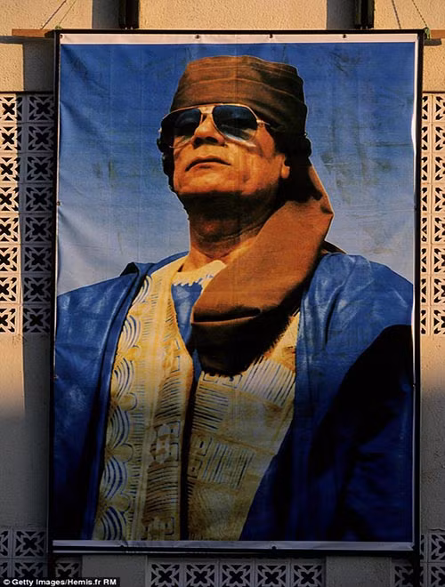 Cư dân Tebu Mohammed cho biết: “Đất nước Libya đã chết cùng ông Gaddafi. Chúng tôi không còn là một quốc gia nữa mà bị chia cắt thành các lãnh địa đánh đấm lẫn nhau”. Ảnh: Chân dung Đại tá Gaddafi.
