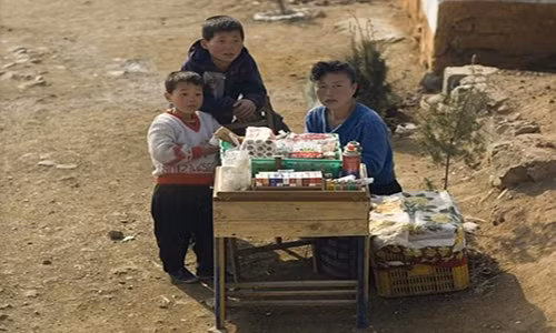 Người phụ nữ Triều Tiên đang ngồi bán hàng bên vệ đường.