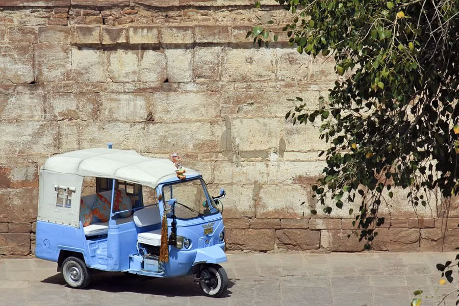 Chiếc xe tuk-tuk màu xanh được sử dụng để chở du khách trong thành phố.