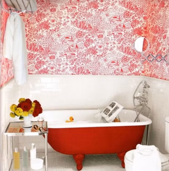 Chiếc bồn tắm màu đỏ nổi bật giữa nền tường trắng.