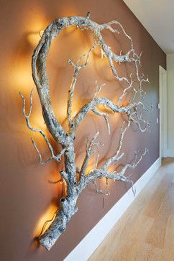 Bức tường gắn cành cây gắn đèn led là một cách trang trí phòng khách cuốn hút và ấn tượng.
