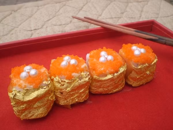 Sushi dát vàng: Những miếng sushi dát vàng là tác phẩm của đầu bếp Philippines Angelito Araneta Jr. Năm miếng sushi với giá 1.800 USD được tạo nên bởi các nguyên liệu dấm balsamic Ý, gạo Nhật Bản, đường Muscovado, cá hồi hồng Na Uy, dưa chuột biển, xoài, cua, nghệ tây hoang dã và mayonnaise. Thứ tạo nên mức giá "khủng" cho món sushi là các viên ngọc trai Palawan, kim cương VVS 20 karat và bọc trong lá vàng.