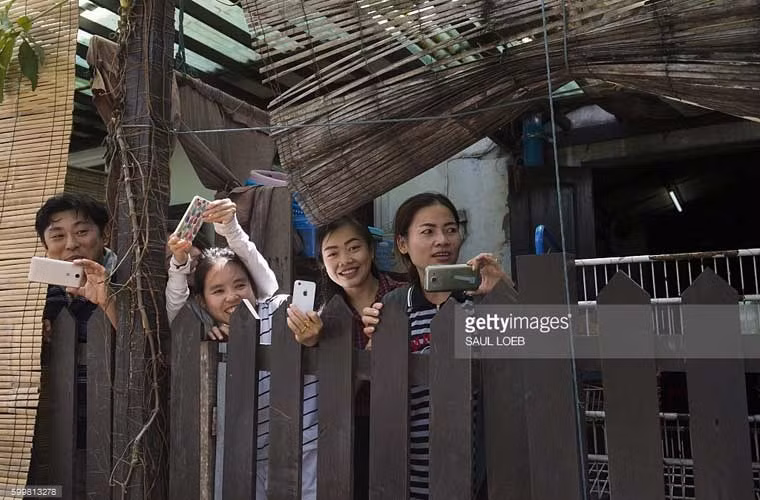 Người dân Lào dùng điện thoại ghi lại trong lúc ông Obama đang mua đồ lưu niệm ở Luang Prabang.