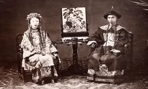Trung Quốc thời nhà Thanh những năm 1860 trong loạt ảnh này đem đến cho độc giả góc nhìn chân thực về cuộc sống của người dân trong một giai đoạn lịch sử. Trong ảnh là vợ chồng một vị quan thời nhà Thanh. Ảnh chụp vào khoảng năm 1861 - 1864.