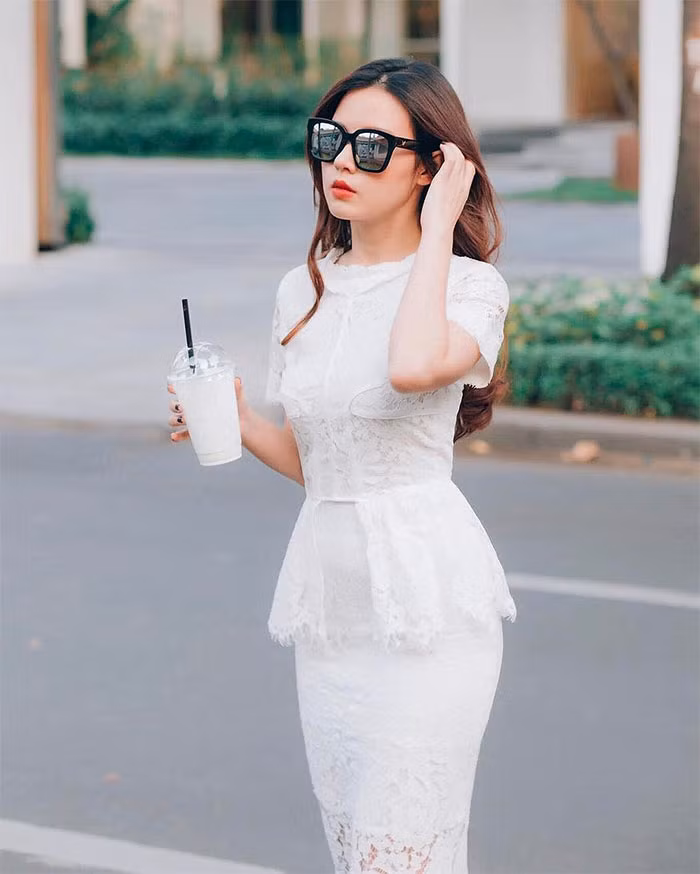 Váy ren trắng ôm sát toàn thân với phần cách điệu peplum khiến Midu càng nữ tính, gợi cảm.