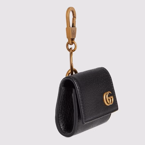 Sản phẩm có vỏ được bọc da màu đen, trong khi móc cài và logo Gucci có màu vàng và được làm bằng kim loại.