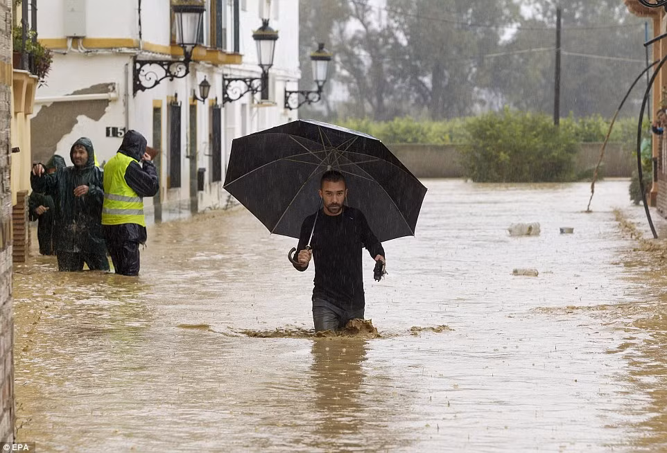 Một người đàn ông lội qua con đường ngập nước ở Dona Ana, Malaga.