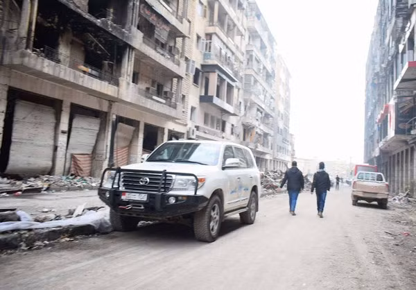 Những chiếc ô tô đỗ trên một con đường đã được dọn dẹp sạch sẽ ở Aleppo.