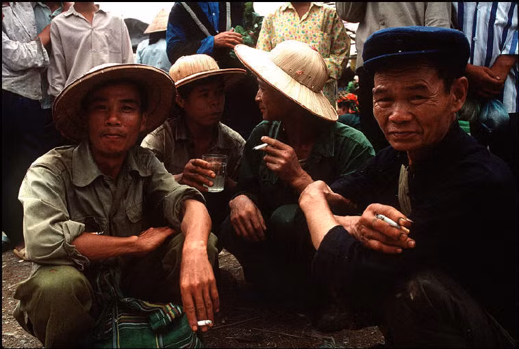 Các quý ông hút thuốc lá, uống rượu ngô ở chợ Trà Lĩnh, 1995. Ảnh: Magnumphotos.com.