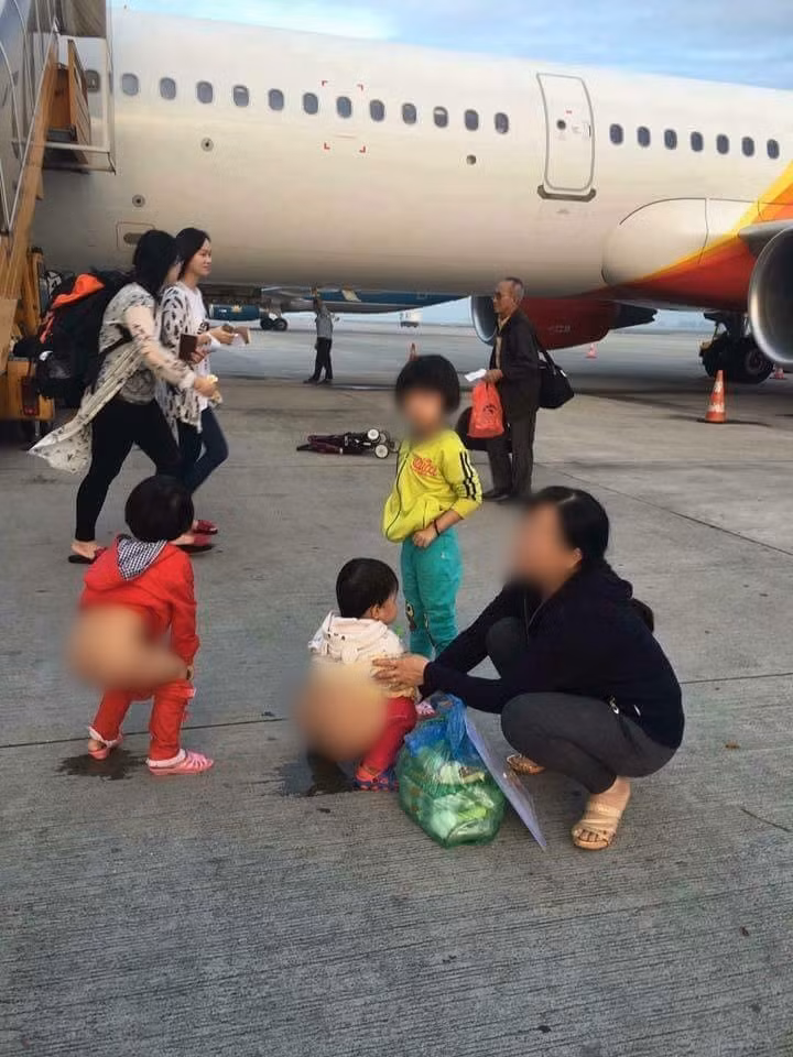 Người phụ nữ cho 2 bé gái đi vệ sinh giữa đường băng sân bay.