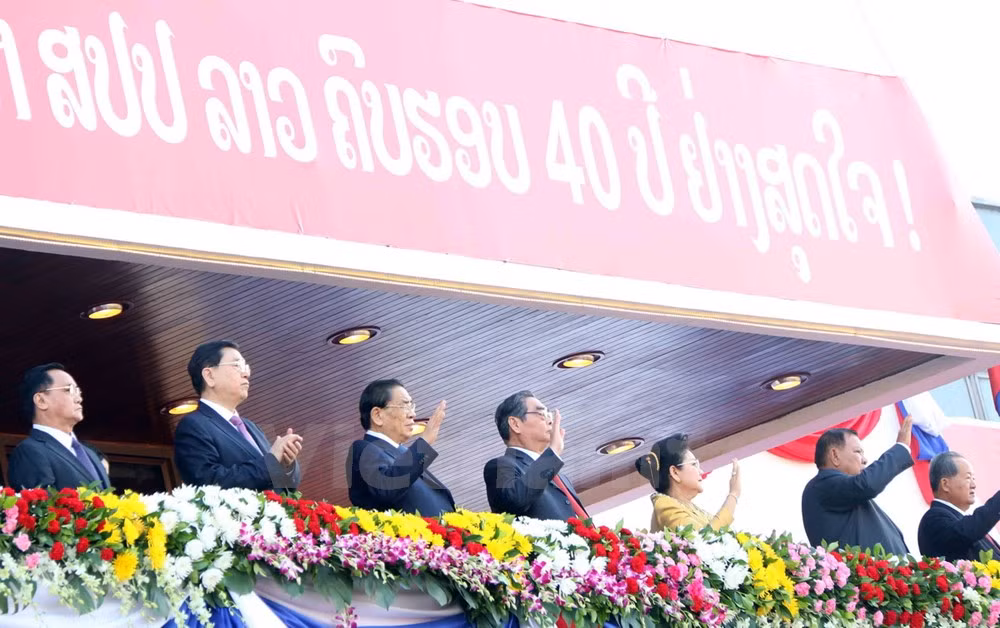 Lãnh đạo Đảng, Nhà nước Lào cùng các vị khách quý đang vẫy chào các khối diễu binh, diễn hành đi qua khán đài.