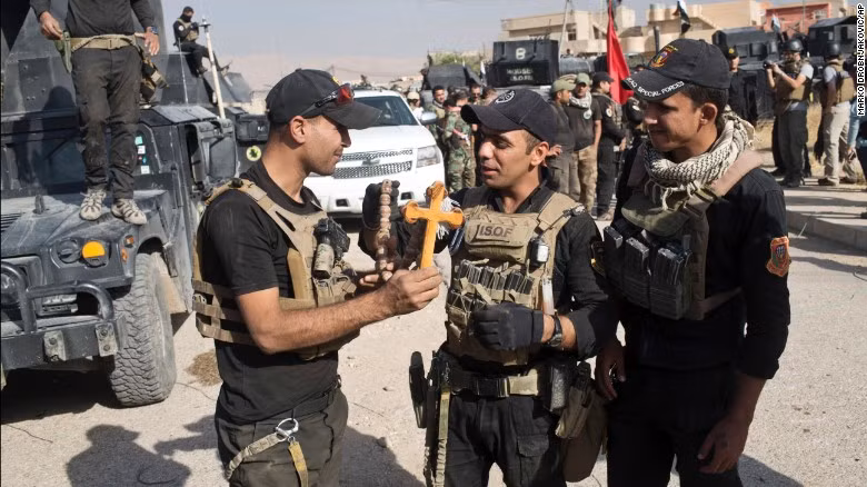 Lính đặc nhiệm Iraq cầm trên tay cây thánh giá tìm thấy ở thị trấn Bartella, nơi nhiều người theo đạo Cơ đốc giáo sinh sống.