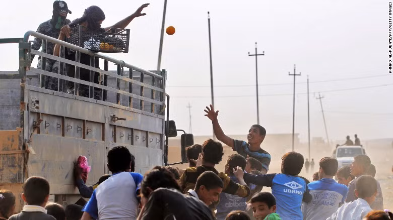 Lính Iraq phát quả cho trẻ nhỏ ở làng al-Khuwayn, phía nam thành phố Mosul sau khi giành lại được làng này từ tay IS.