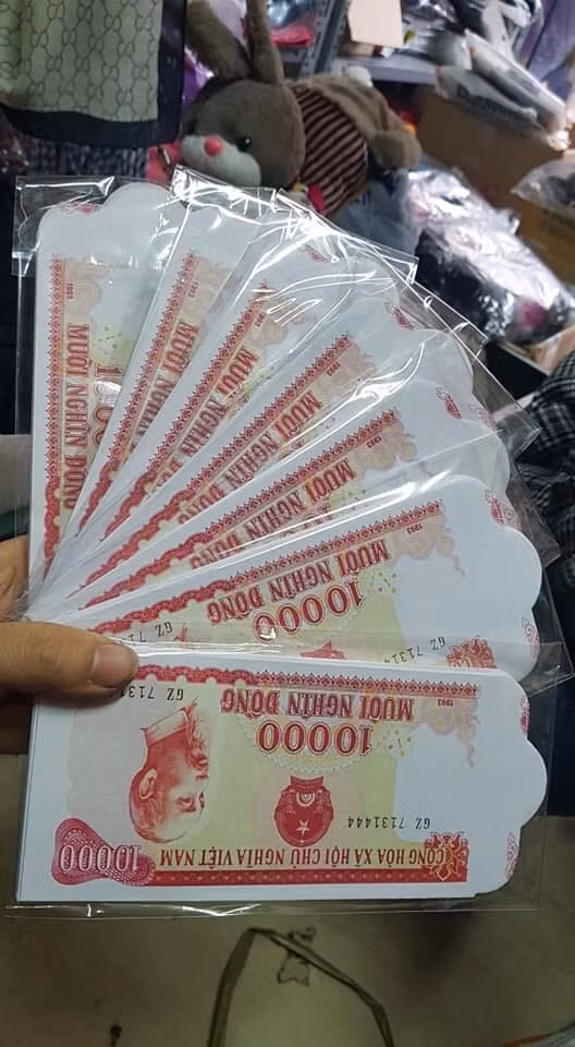 Càng gần Tết Nguyên đán, thị trường phong bao lì xì càng trở nên sôi động. Bên cạnh các mẫu bao lì xì hình heo ngộ nghĩnh hay đội tuyển Việt Nam...nhiều chị em còn đang tìm mua loại bao lì xì hình tờ tiền cotton 10.000 màu đỏ. Ảnh: FB Nguyễn Thúy.