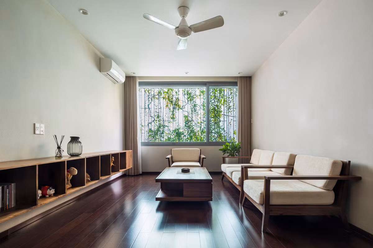 Phòng khách đơn giản, thoáng mát nhờ lớp cây bao phủ phía trước.