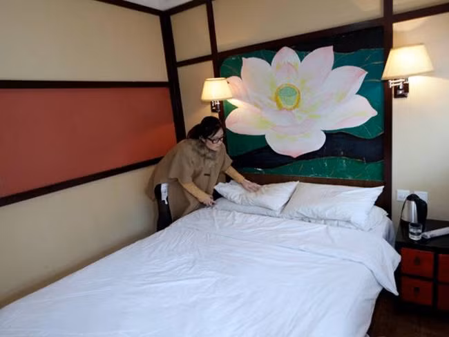 Cô kiểm tra nệm, gối và giường ngủ để đảm bảo khách có giấc ngủ ngon nhất.