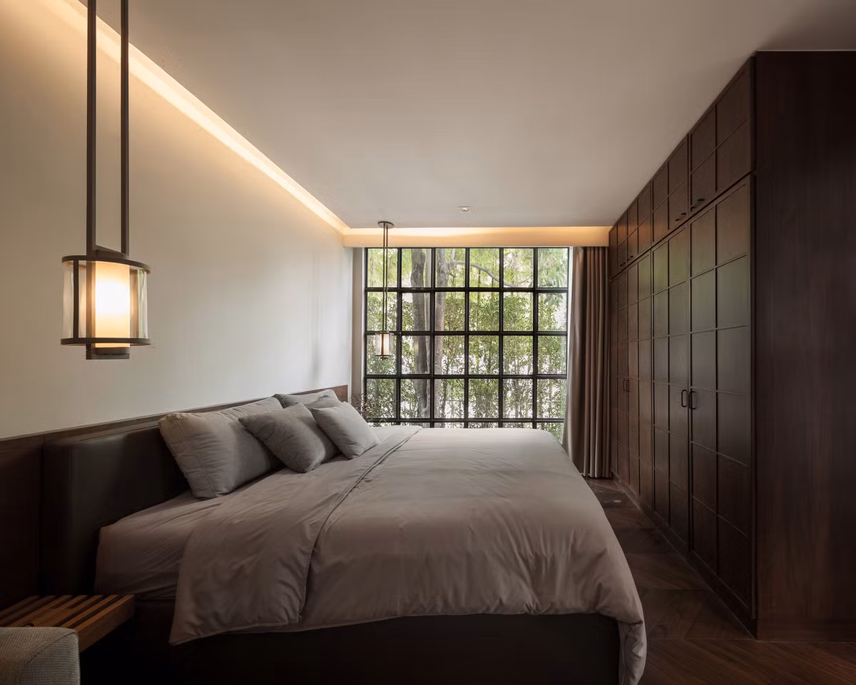 Phòng ngủ có cửa sổ kính lớn nhìn ra bên ngoài. Nguồn ảnh: Archdaily.