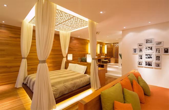 Phòng ngủ rộng thoáng và ấm áp với chất gỗ, vải, màn và đèn trang trí. Tất cả màu sắc, kiến trúc, đồ nội thất đều gắn kết chặt chẽ với nhau tạo nên một không gian hài hòa và thư thái.