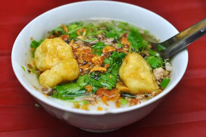 Bánh đúc nóng Hà Nội dẻo, mịn, có vị ngọt thanh của nước xương, và thơm hương rau mùi. Bát bánh đúc bốc khói có chút thịt xay xào cùng mộc nhĩ, đậu rán cùng rau thơm. Ảnh: Zing.