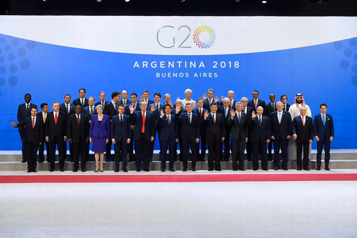 Thủ tướng Đức Merkel không có mặt trong bức ảnh “gia đình” này do đến muộn sau khi chiếc chuyên cơ chở bà phải hạ cánh khẩn cấp do gặp vấn đề kỹ thuật khi đang trên hành trình tới Argentina.
