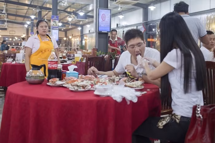 Hai người này không phải vợ chồng, không phải người yêu, thực chất đây là dịch vụ kỳ lạ: bóc ghẹ cho khách được cô gái này cung cấp